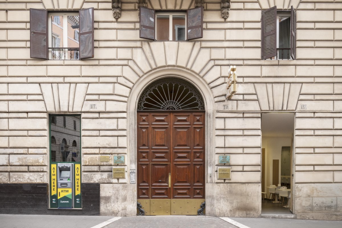 Classic stone exterior facade of Hotel Cortina in Rome, showcasing the main entrance and an integrated Euronet ATM - Hotel Cortina, BZAR hotels in Rome